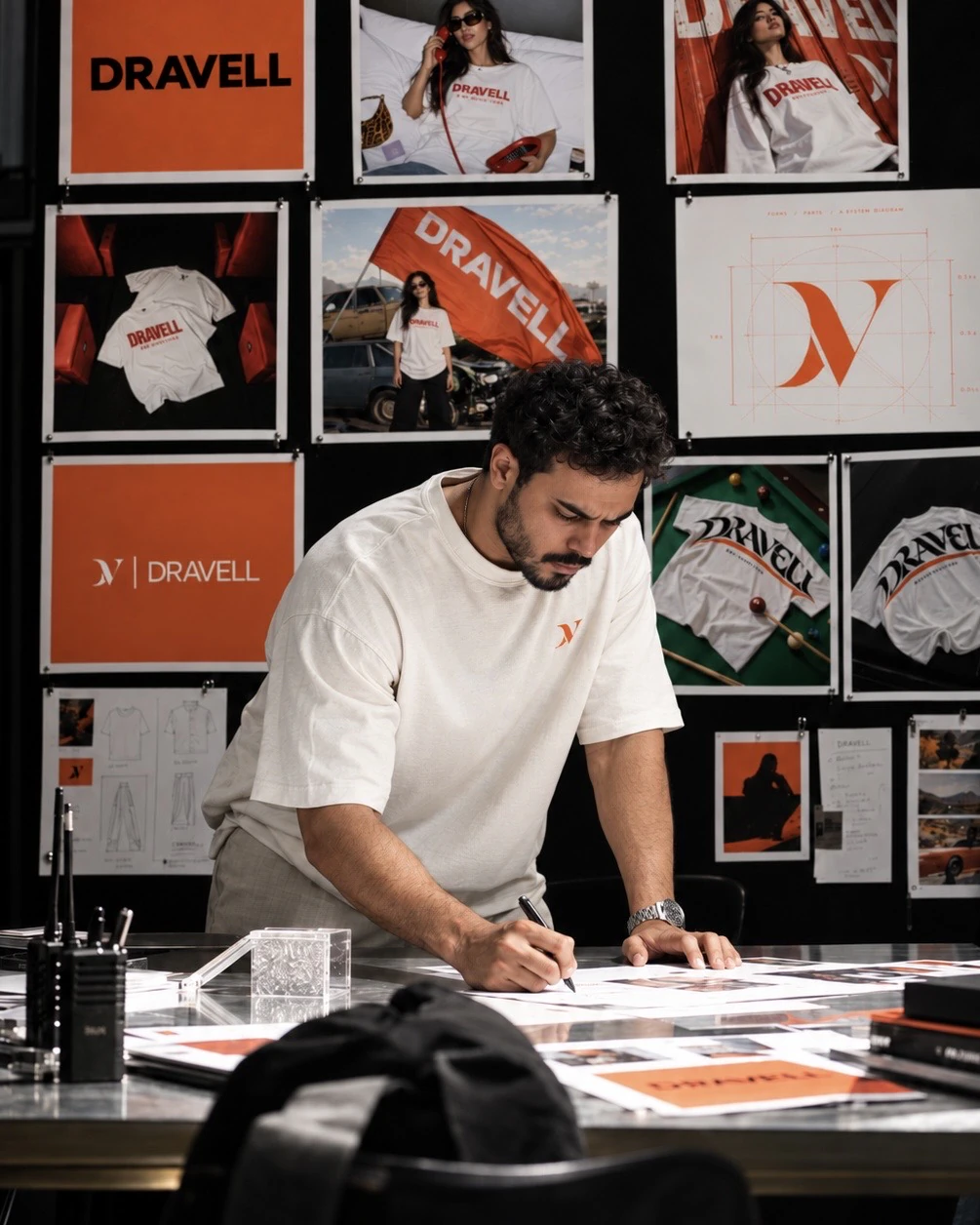 DRAVELL founder Abderrahman Sadki at a design desk with campaign boards behind him.